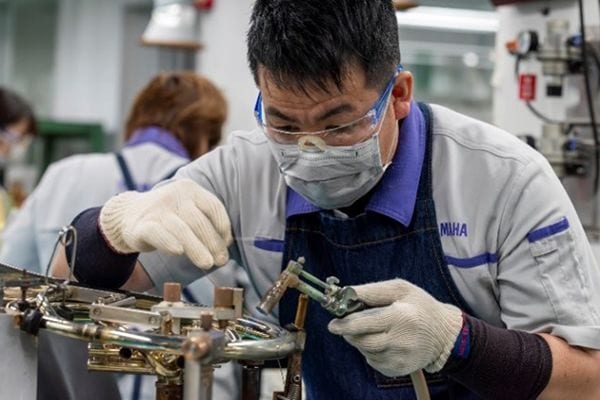 Een vakman soldeert metalen onderdelen met loodvrij soldeer.