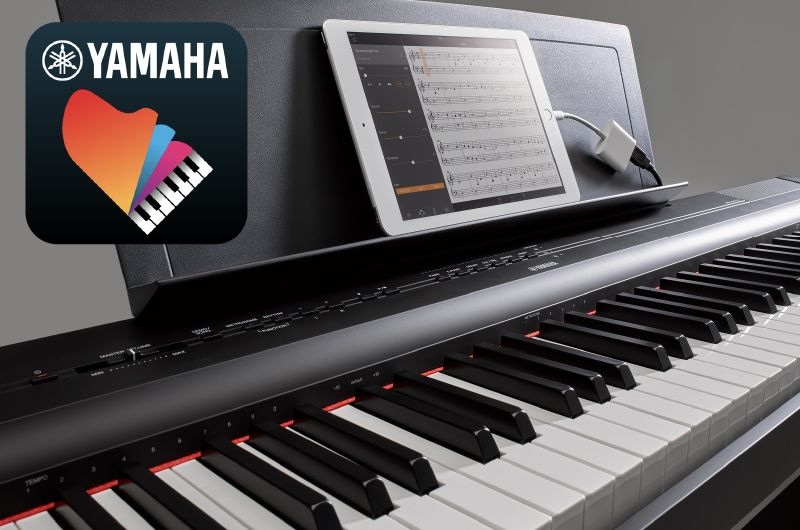 A photo of the Yamaha “Smart Pianist” app icon, together with a tablet displaying a musical score placed on the music stand of the P-125a