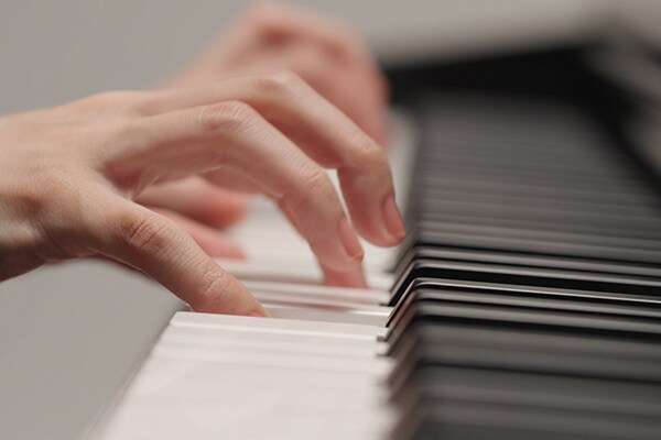 Handen die spelen op het Graded Hammer Standard (GHS)-klavier