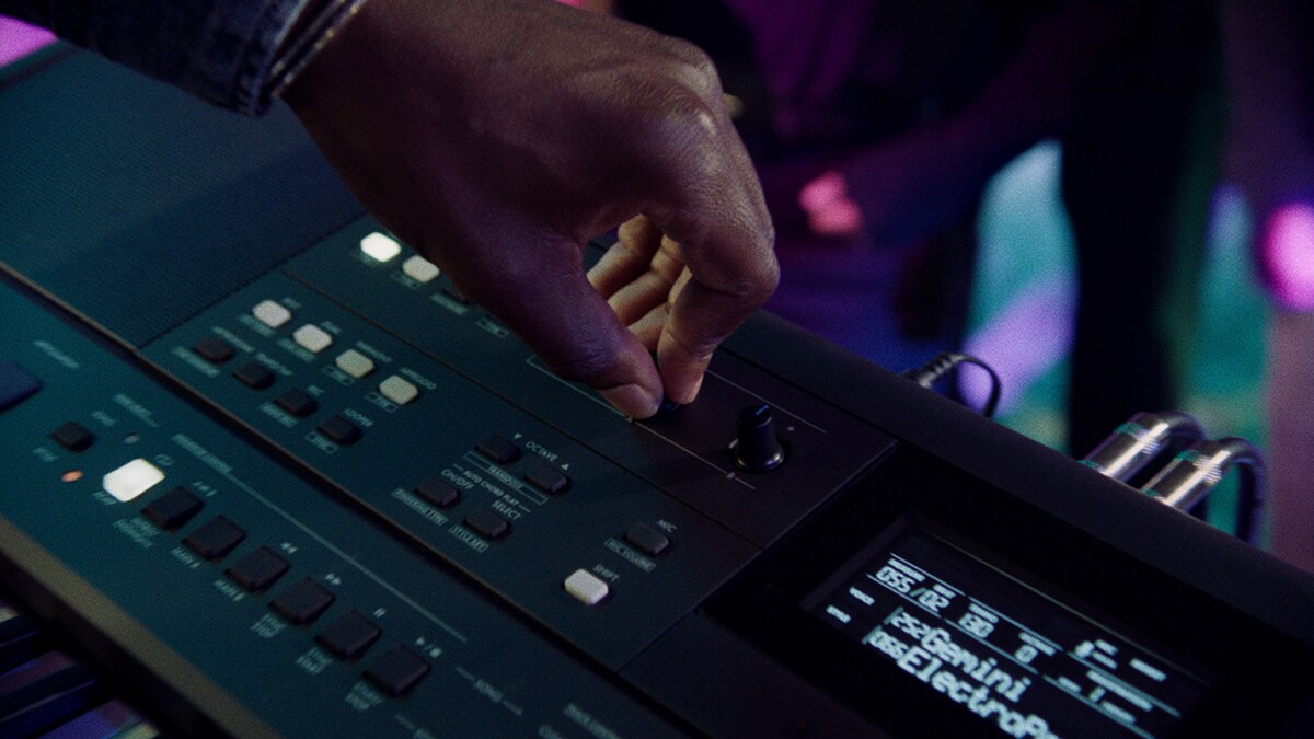 Een persoon bedient de Live-regelknop van de PSR-E483