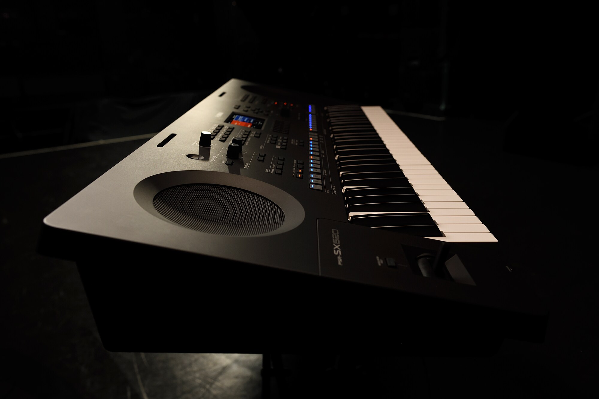 Een keyboard op een statief onder podiumverlichting