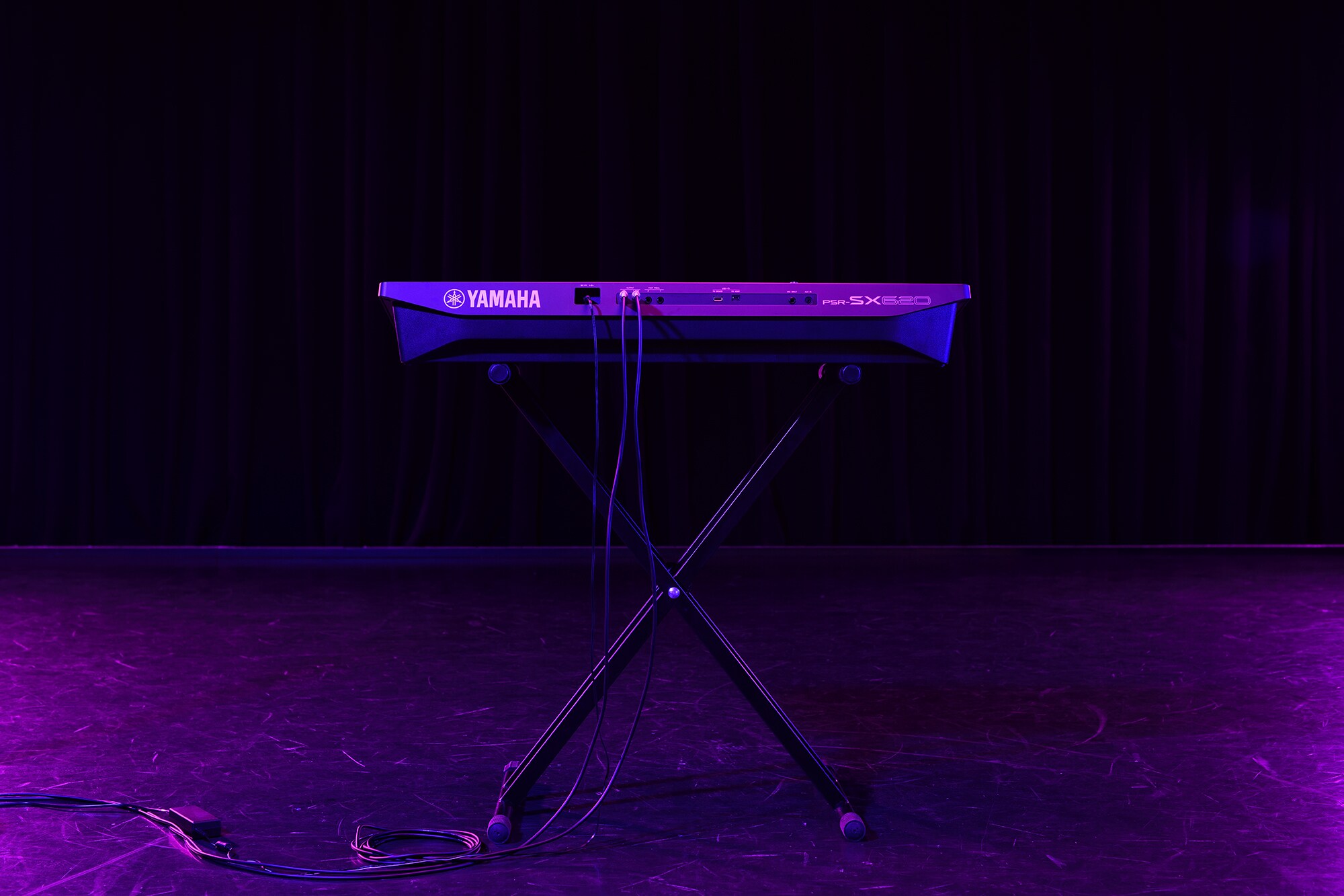 Een keyboard op een statief onder podiumverlichting