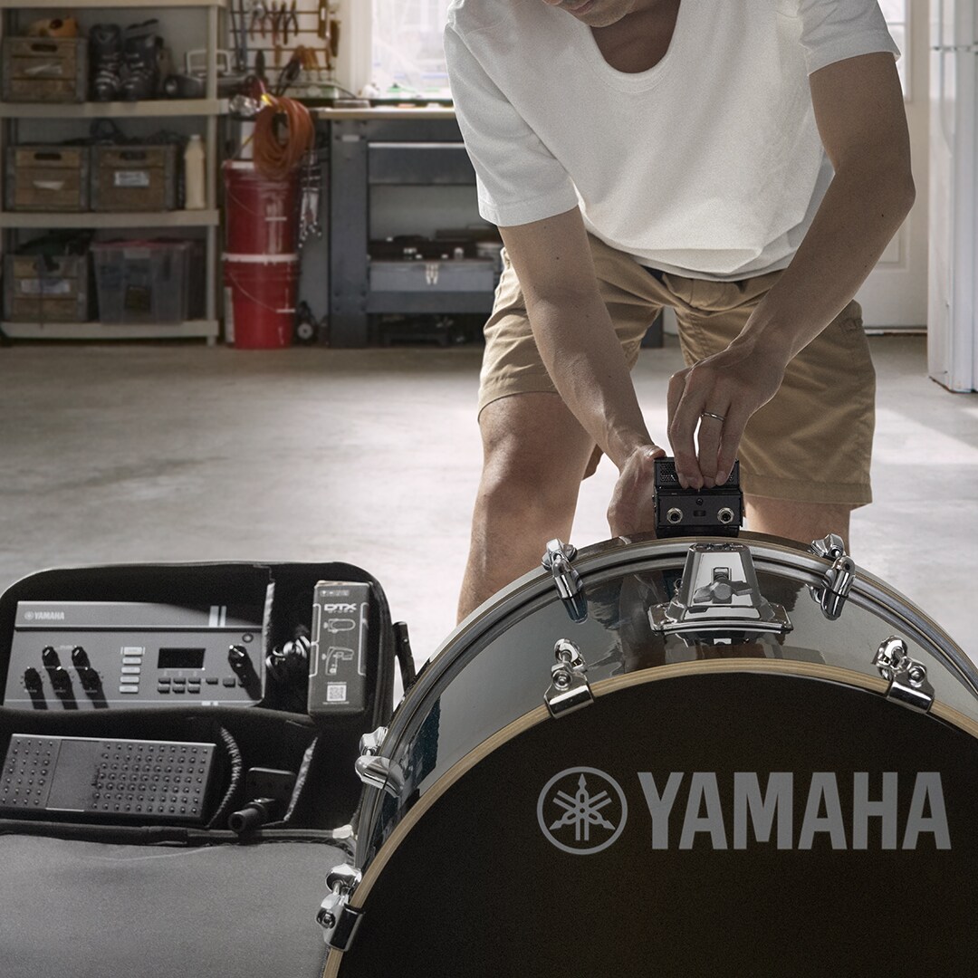 Drummer die de EAD20-sensorunit op een basdrum bevestigt voor een snelle opstelling en geoptimaliseerde registratie van het drumgeluid.