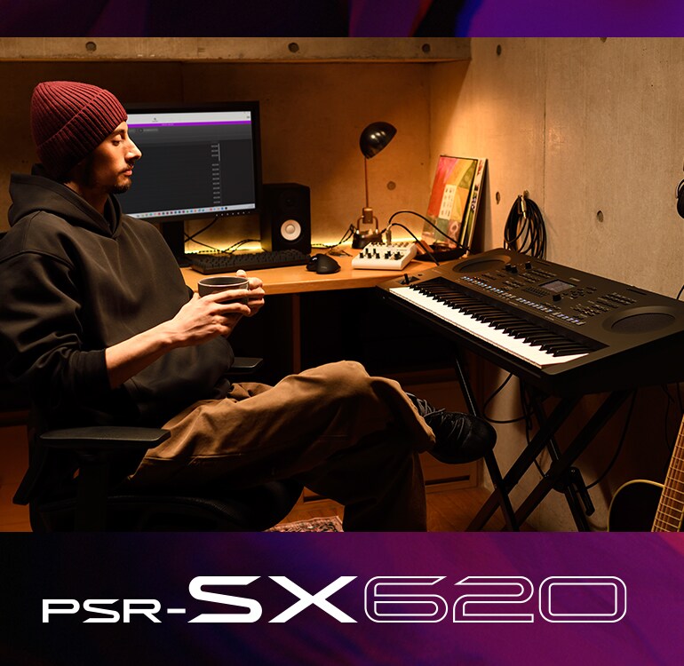 Iemand die koffie drinkt en achter een PSR-SX-keyboard in een thuisstudio zit.