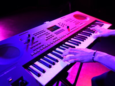 Close-up van handen die tijdens een live-optreden op een keyboard spelen.