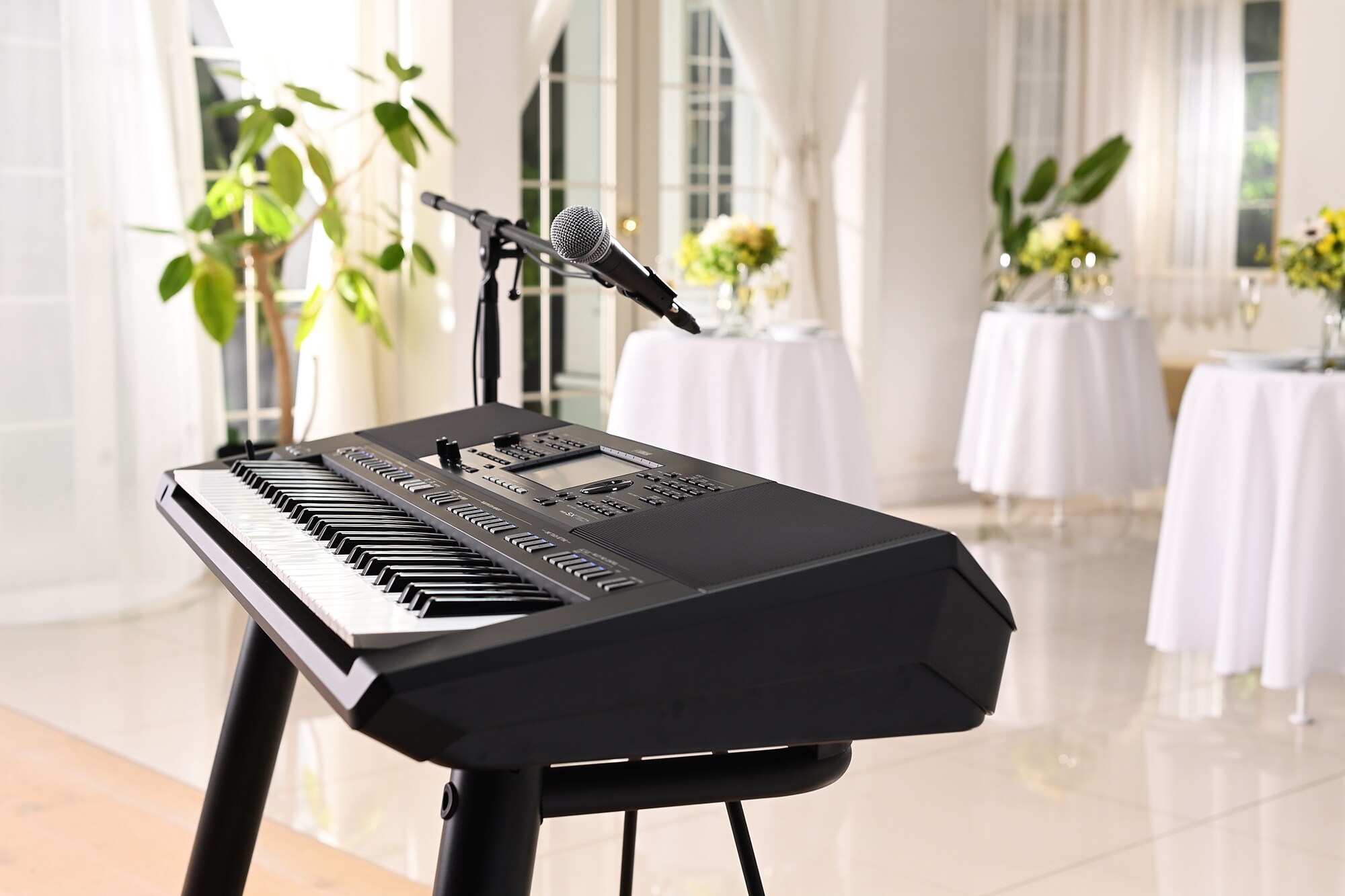 Yamaha Arranger Workstation PSR-SX720+ met microfoonstandaard op een feestlocatie