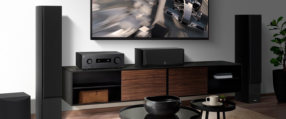 De RX300A, een centerspeaker, frontspeakers en een subwoofer in een kamer.