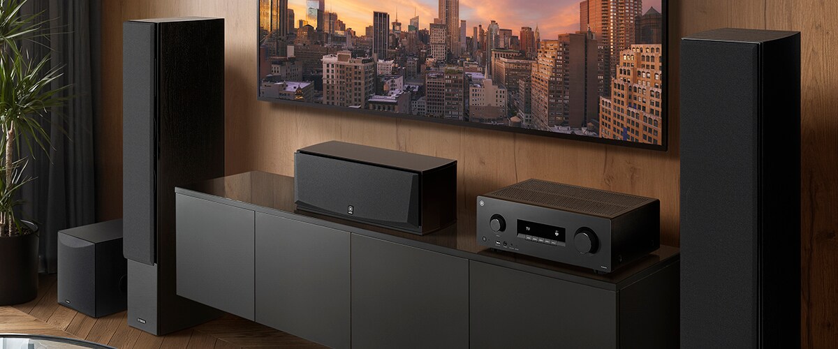 De RX500A, een centerspeaker, frontspeakers en een subwoofer in een kamer.