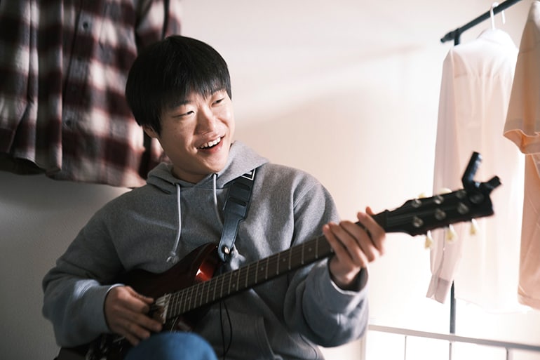 Een man die voor het eerst probeert gitaar te spelen