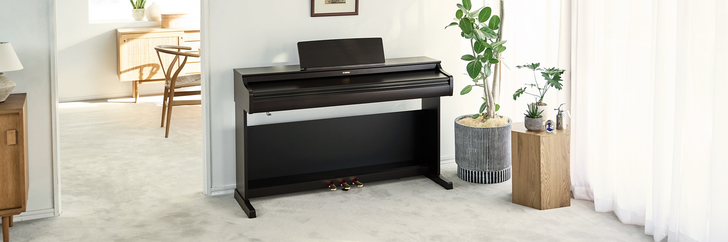Een ARIUS-piano in een woonkamer met gesloten klep, harmonieus geïntegreerd in het interieur