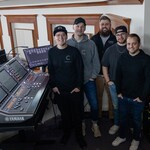 Members of the Christ Community Chapel audio team standing beside a Yamaha RIVAGE PM mixing console.