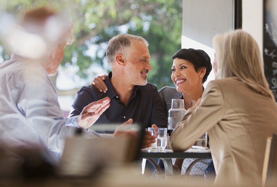 A group of people enjoying a conversation at a restaurant.